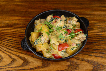 Potato fry with tomatoes and cheese in a pan
