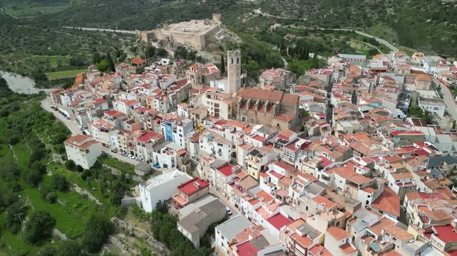 Aerial view of Cervera del Maestre with its clustered buildings and the prominent castle perched above, creating a captivating contrast, Cervera del Maestre, Valencian Community, Spain.