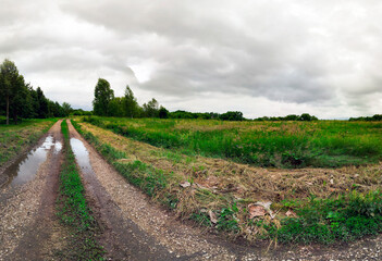 Obraz premium Gravel path across green countryside