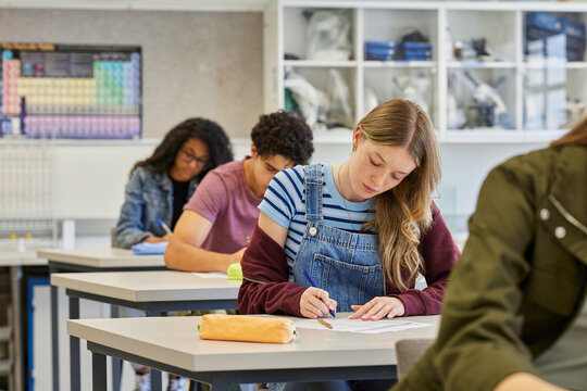 Secondary students taking test sitting in a line