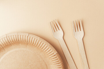 Set of wooden forks and kraft paper tableware flat lay on pastel background