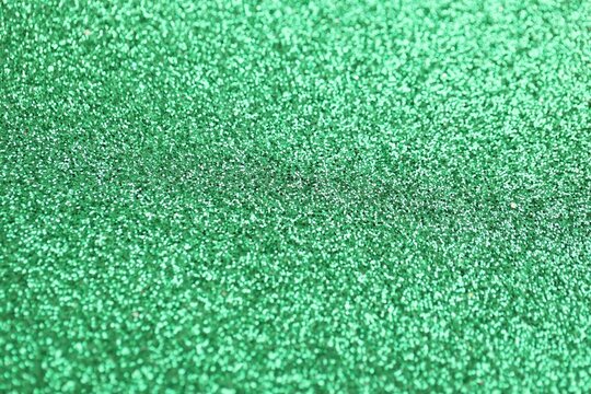 Fototapeta Beautiful green glitter sparks texture as background with shallow depth of field