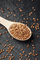 Healthy buckwheat seeds displayed on a wooden spoon for culinary use