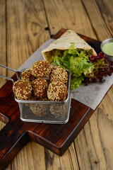 falafel with pita bread with herbs on a wooden board macro photo
