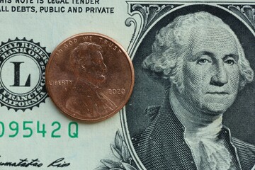 American cent coin on dollar bill close up. United States currency