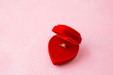 Square diamond ring in red heart jewelry box on pink background