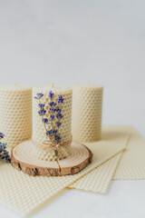 Beeswax candle on wood slice with lavender bouquet and wax sheets