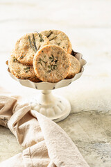 Shortbread cheese cookies with aromatic herbs on rustic textured background isolated. Savory parmesan cookies for party