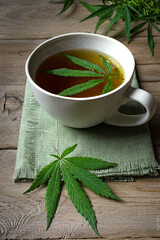 Cup of Hemp herbal tea and green hemp leaves