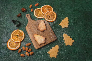 Holiday baking with tree shaped cookies and oranges for christmas food concept and decorative...