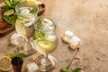 Naklejka na ściany i meble Mojito long rum drink with fresh mint, lemon juice, ice cubes and soda on brown textured background. Summer party cocktails with copy space