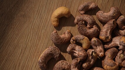 Shot over raw cashew nuts on wooden surface