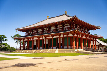 Fototapeta premium Majestic big red temple set amidst expansive, serene temple grounds with lush greenery.