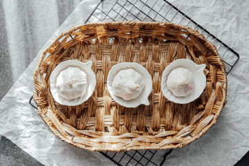 Garlic bulbs arranged in small dishes on a woven basket