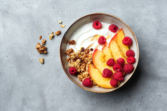 Granola bowl with yogurt, peach, raspberry and honey