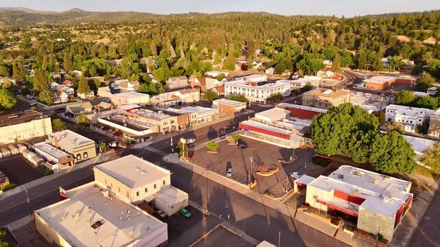 Susanville, United States - 20 June 2025: Aerial view of the town's buildings nestled amid lush green trees, revealing a charming, compact urban landscape.