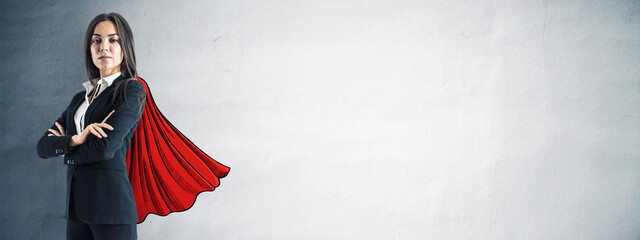 Confident businesswoman in suit with illustrated red cape standing against textured wall background, symbolizing leadership and empowerment. © Who is Danny