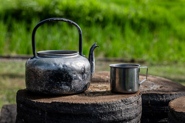 Old teapots were made from aluminum on Wood Table. Outdoor Camp. Picnic Green Rice field background
