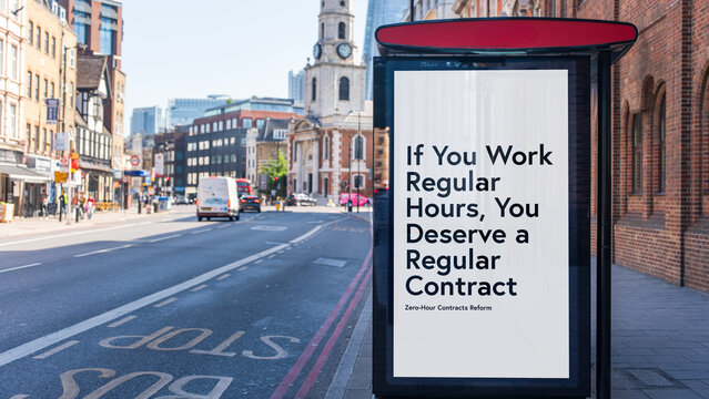 Bus stop billboard poster reading “If you work regular hours, you deserve a regular contract” on city street, London