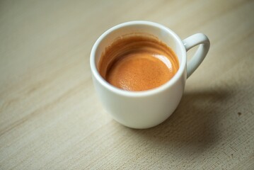 Espresso Tools: Professional Portafilter and Glass Cup with Rich Crema on Rustic Wooden Table Espresso Perfection: Dark Roast Coffee with Crema, Portafilter, and Chrome Machine Parts on Wood