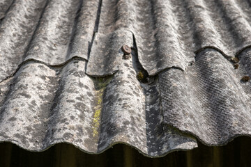 Old and very dangerous asbestos roof. Asbestos dust in the environment. Asbestos removal