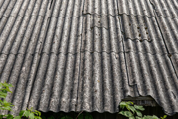 Old and very dangerous asbestos roof. Asbestos dust in the environment. Asbestos removal