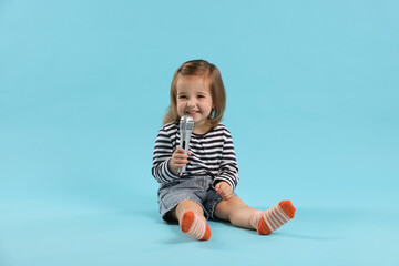 Naklejka premium Cute little girl with microphone on light blue background