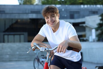 Teenage boy riding bicycle on city street