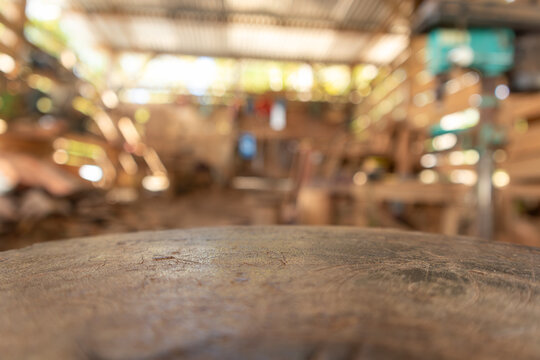 Empty wood board table for product placement or design mockup with workshop industrial background