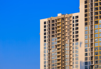 Fototapeta premium City view on a sunny day. Modern building and houses against the blue sky.