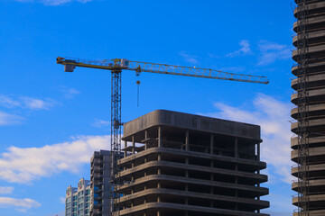 Construction of buildings and high-rise cranes against the sky