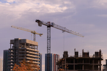 Fototapeta premium Construction of buildings and high-rise cranes against the sky