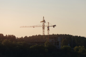 Construction of buildings and high-rise cranes against the sky
