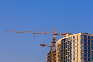 Construction of buildings and high-rise cranes against the sky