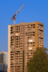 Fototapeta premium Construction of buildings and high-rise cranes against the evening sky