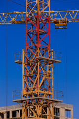 Construction of buildings and high-rise cranes against the blue sky