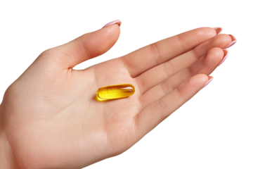 A light-yellow capsule rests in a woman's open palm