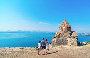 Family visit in ancient monastery called Sevanavank in Armenia in summertime 