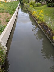 Newly channelized or straightened river. The older side on the right is a bit more natural looking than the new side on the left, consisting of cement building blocks.