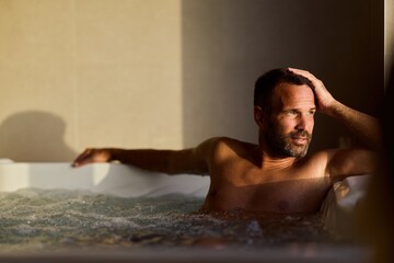 Man Relaxing in a Hot Tub at Sunset, Enjoying Tranquility