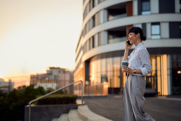 Asian Business Woman Talking on Phone Outside a Modern Building