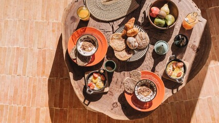 Rustic breakfast setup with assorted breads and fruits.