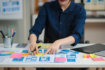 Female coder or developer working using a computer display and smartphone in problem solving at...