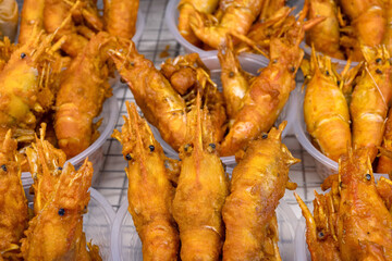 A tasty display of deep fried shrimp shellfish, a popular seafood snack sold from street food...