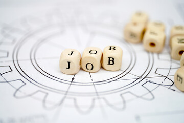 Wooden beads spell job on engineering blueprint showcasing career opportunities and aspirations in...