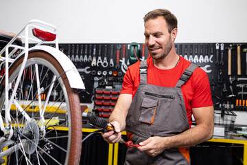 Bicycle service and maintenance. Professional serviceman checking air pressure in bicycle rear...