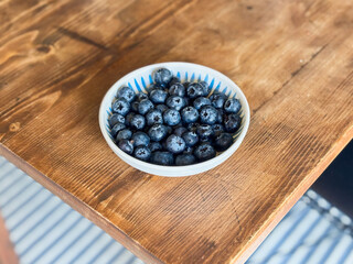 Small Bowl of Blueberries on the Corner of a Wooden Table