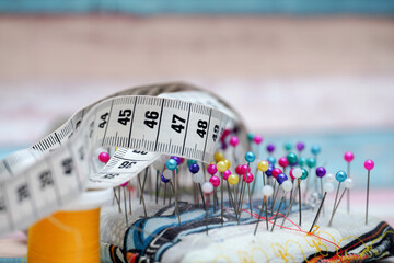 Measuring tape and colorful pins on fabric for sewing projects in a creative workspace