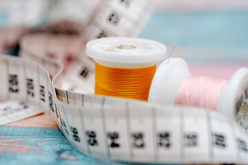 Colorful sewing threads and measuring tape displayed on a crafting table in a creative workspace