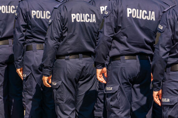 Polish police officers in uniform during the Police Day ceremony, rear view of a group of officers.